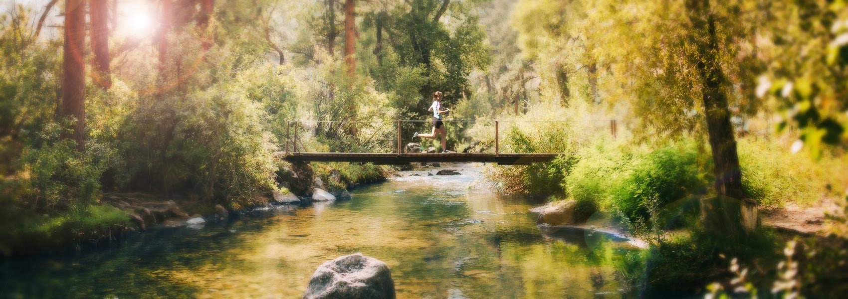 Woman running across bridge at Eatons' Ranch